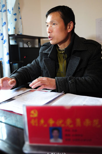 辦公室裡，花全向前來咨詢的村民解釋村裡的補助政策